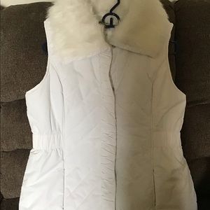 White puffy vest with white fur collar.